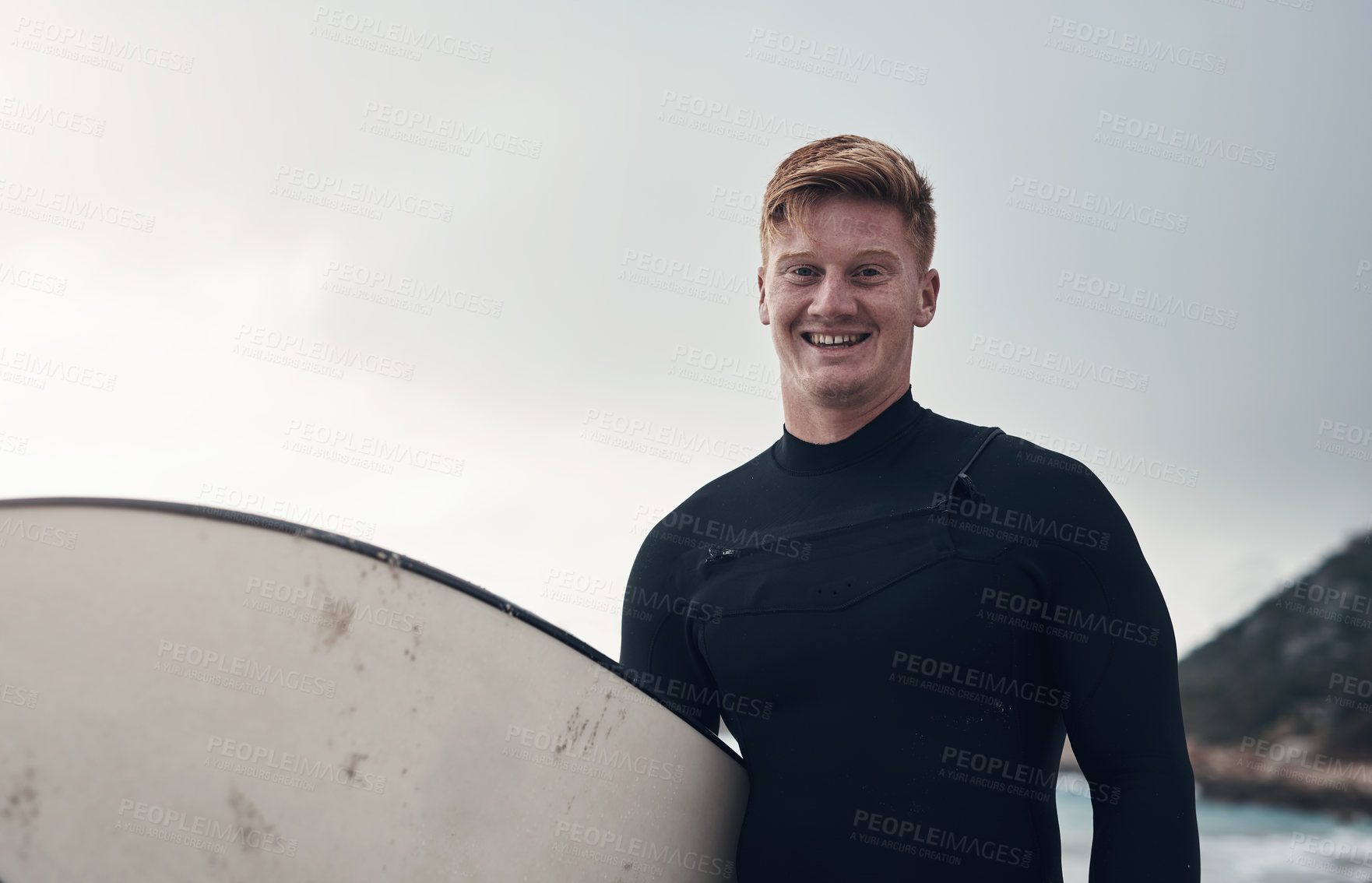 Buy stock photo Cropped shot of a man holding his surfboard while at the beach