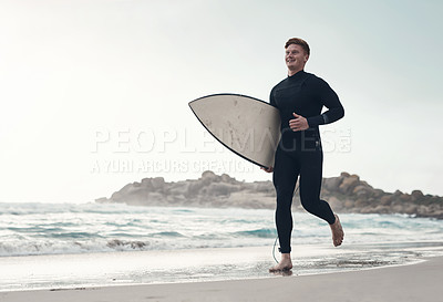 Buy stock photo Shot of a young man along the shoreline with his surfboard