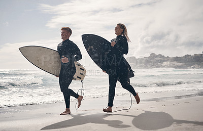 Buy stock photo Shot of a young couple out surfing together at the beach