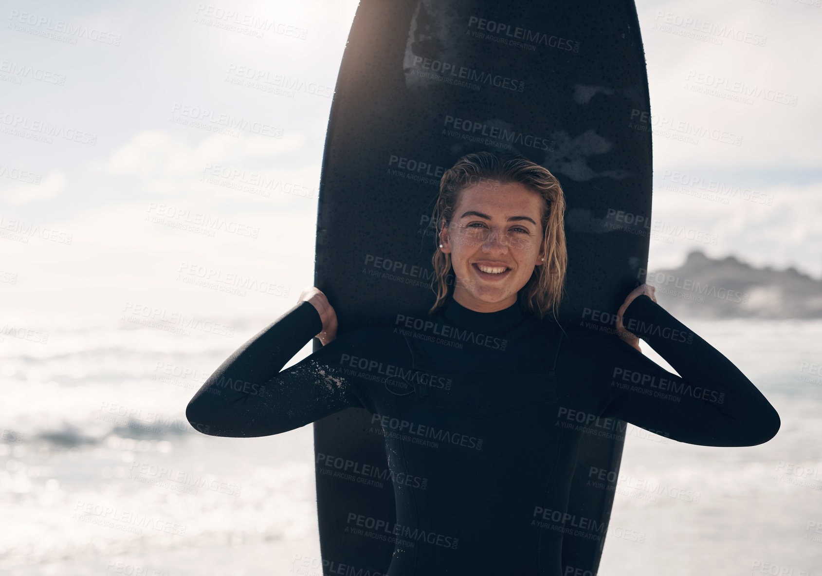 Buy stock photo Cropped shot of a young woman standing on the beach with her surfboard