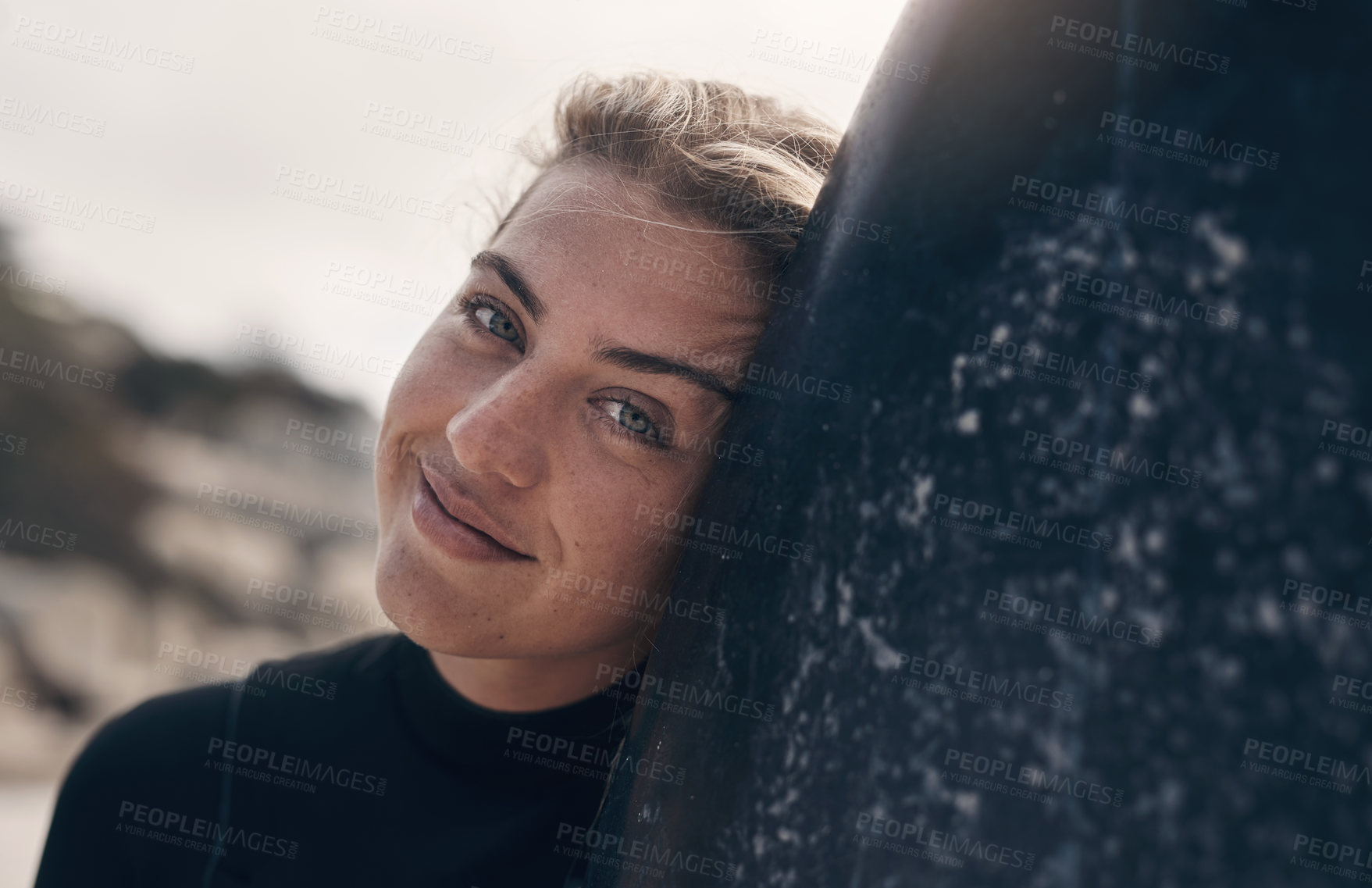 Buy stock photo Cropped shot of a young woman standing on the beach with her surfboard