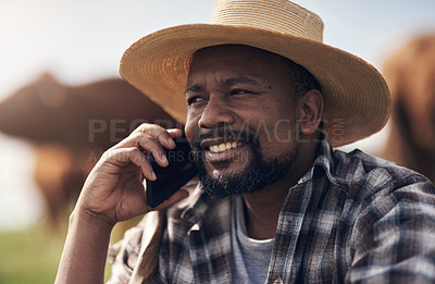 Buy stock photo Shot of a mature man using a smartphone while working on a cow farm