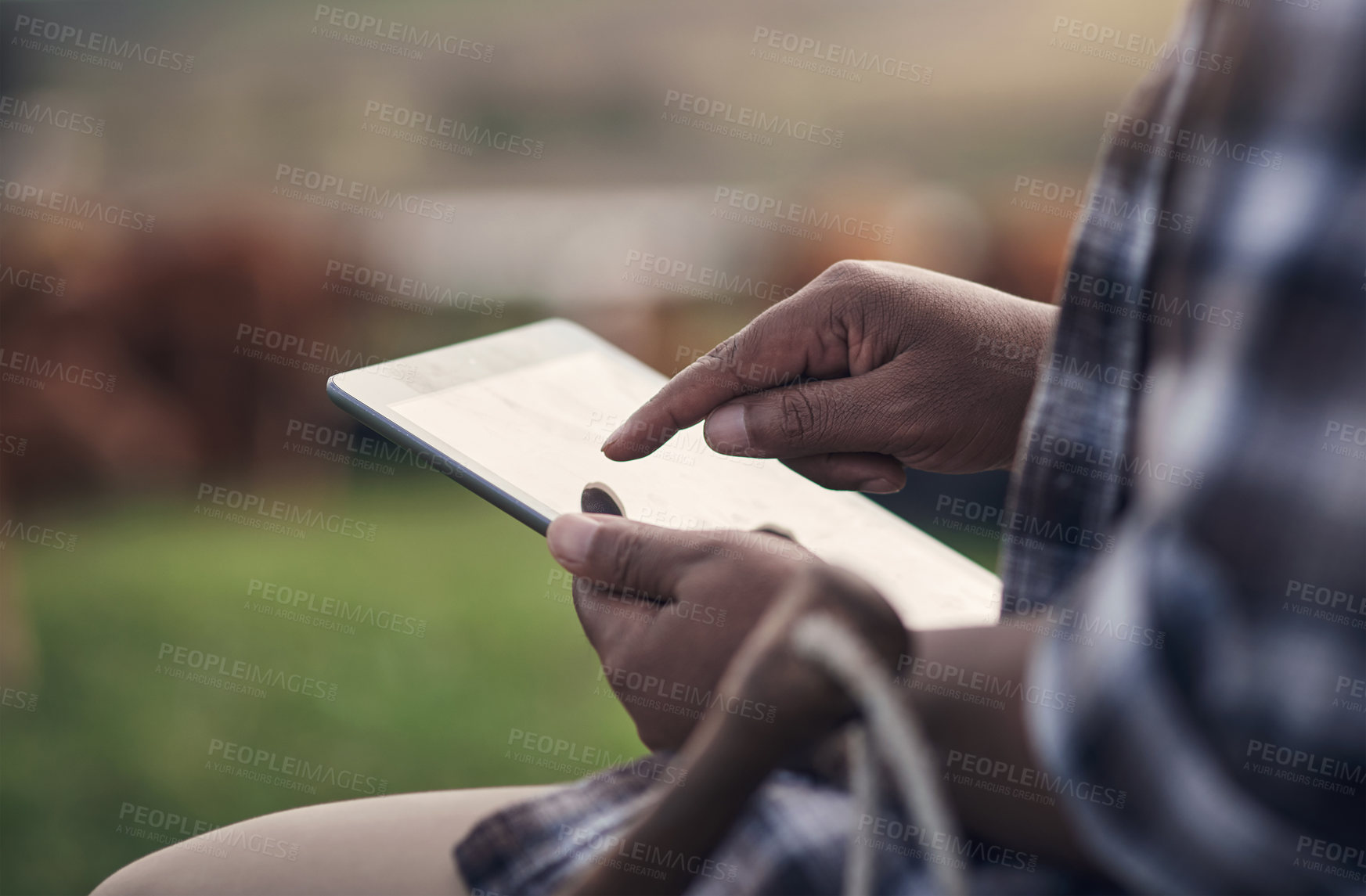 Buy stock photo Shot of an unrecognisable man using a digital tablet while working on a cow farm