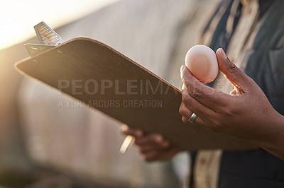 Buy stock photo Shot of an unrecognisable farmer inspecting the quality of eggs on his farm