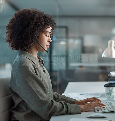 Buy stock photo Shot of a young female agent working in a call centre typing while on a call