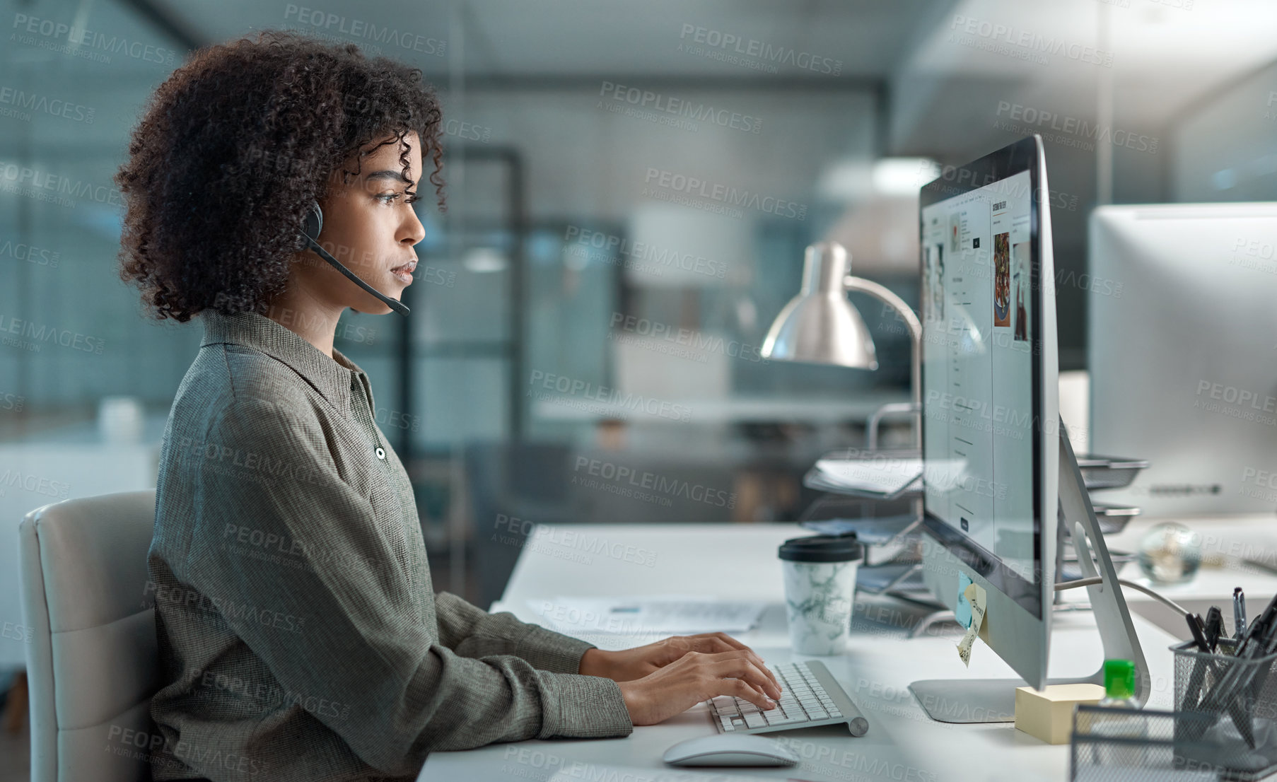 Buy stock photo Shot of a young female agent working in a call centre focused while typing