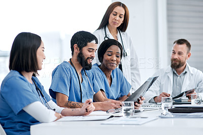 Buy stock photo Shot of a group of medical practitioners analysing x-rays in a hospital boardroom
