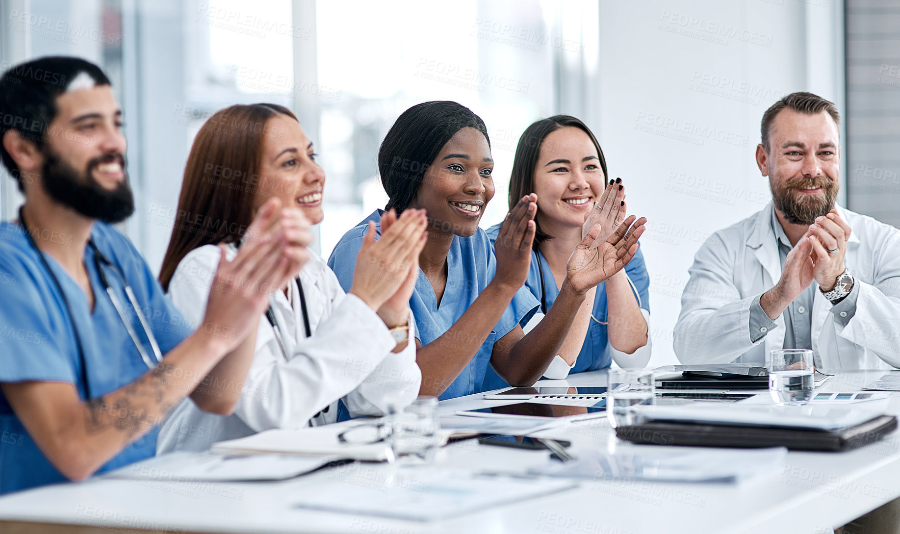 Buy stock photo Shot of a group of medical practitioners applauding during a meeting in a hospital boardroom