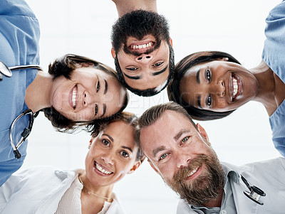 Buy stock photo Portrait of a group of medical practitioners joining their heads together in a huddle