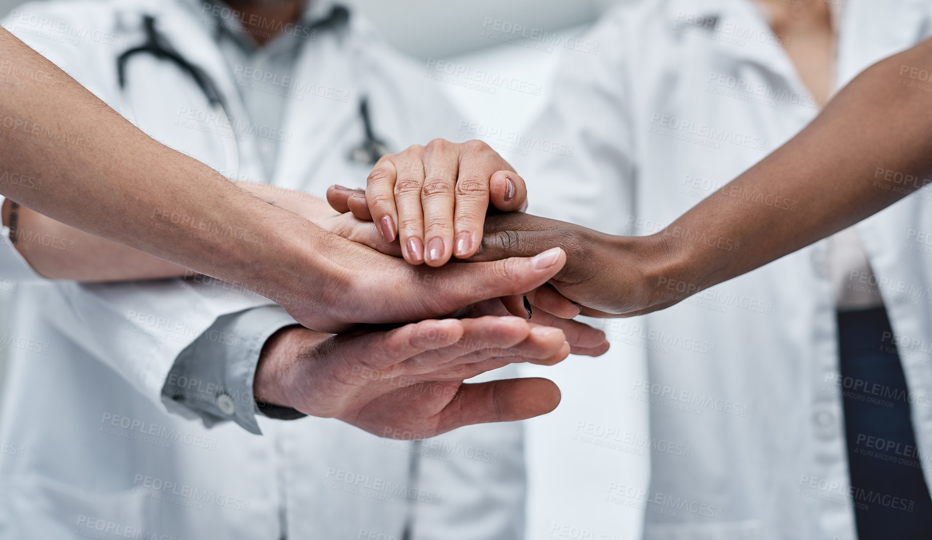 Buy stock photo Closeup shot of a group of medical practitioners joining their hands together in a huddle