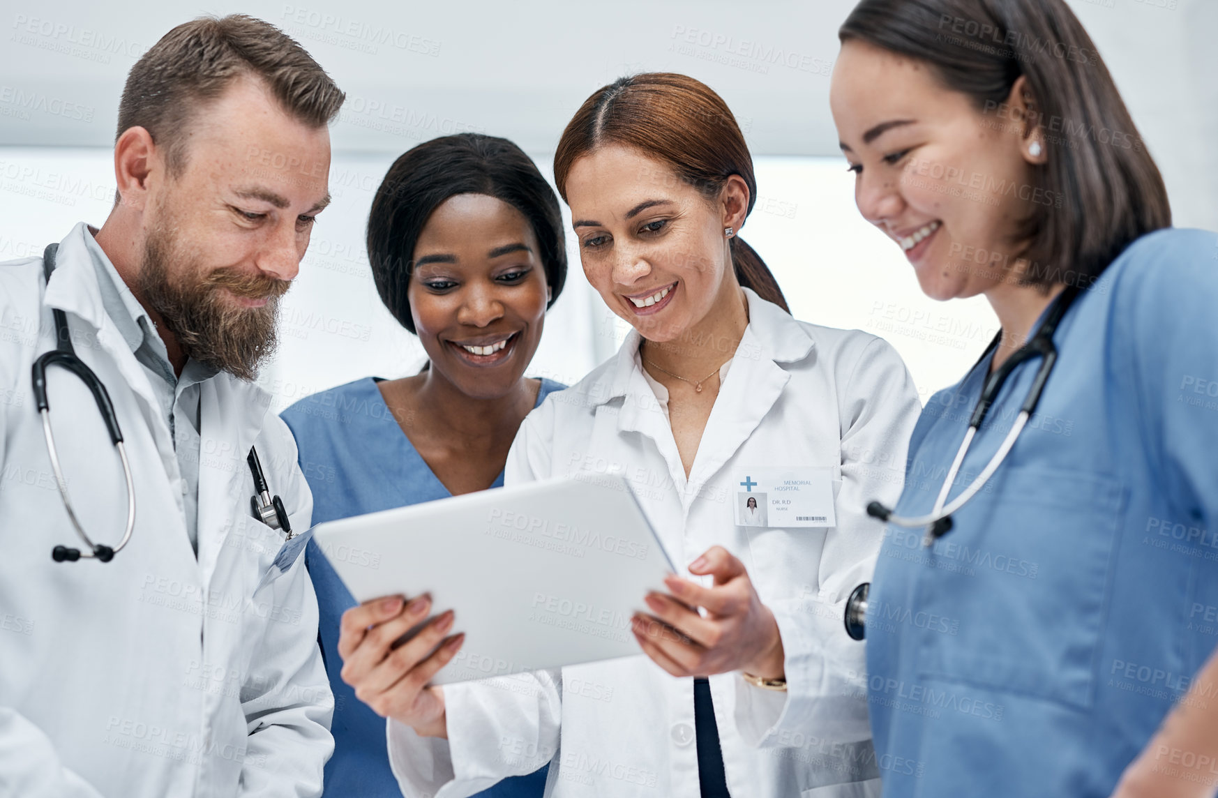 Buy stock photo Shot of a group of medical practitioners using a digital tablet together in a hospital