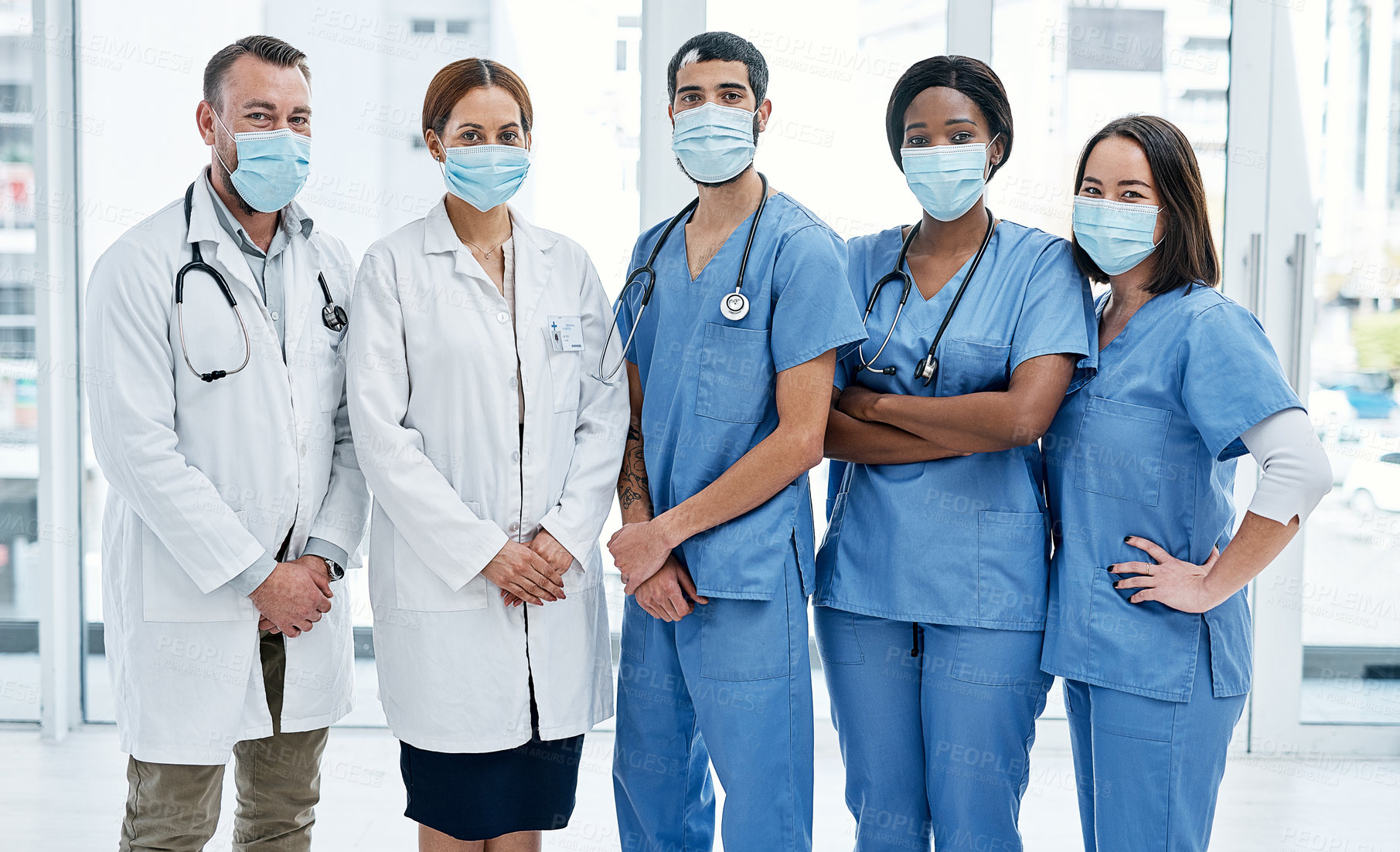 Buy stock photo Portrait of a group of medical practitioners wearing face masks in a hospital