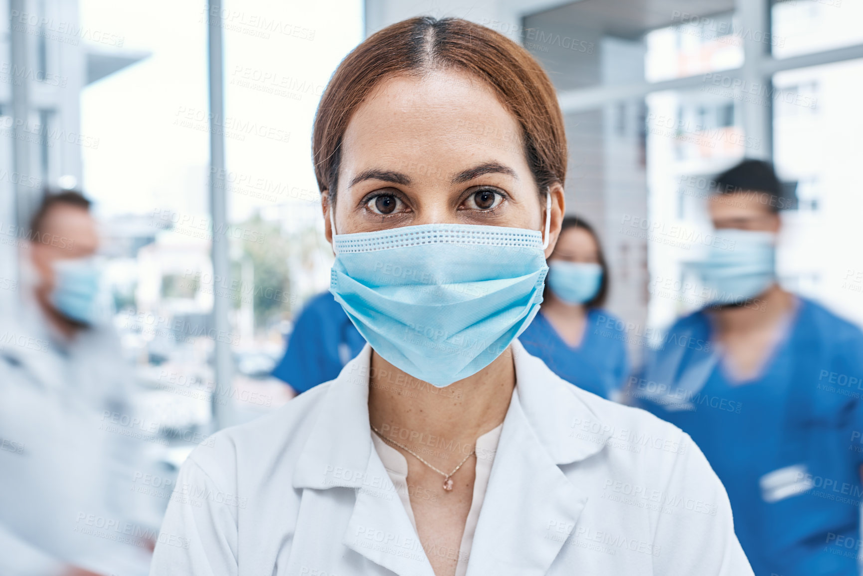 Buy stock photo Portrait of a doctor wearing a face mask in a busy hospital