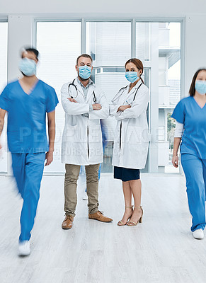 Buy stock photo Portrait of two doctor wearing face masks in a busy hospital