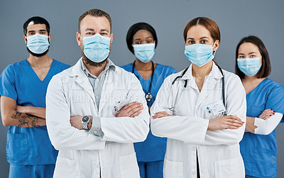 Buy stock photo Portrait of a group of medical practitioners wearing face masks against a grey background