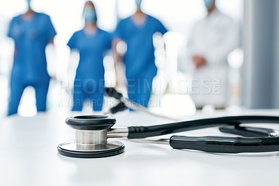 Buy stock photo Closeup shot of a stethoscope in a hospital with medical practitioners in the background