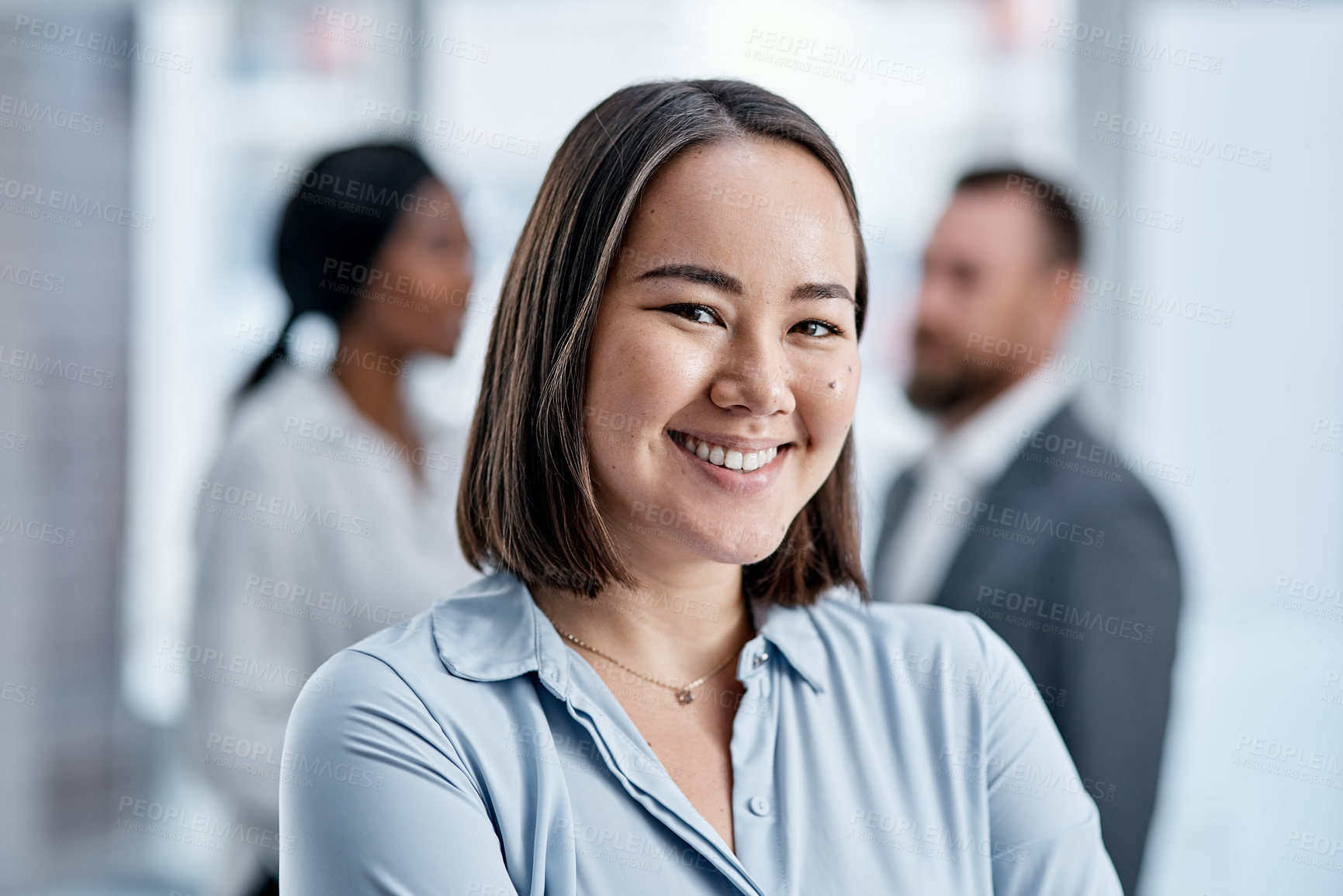 Buy stock photo Portrait of a businesswoman standing in an office with her colleagues in the background