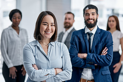 Buy stock photo Portrait of a businesswoman standing in an office with her colleagues in the background