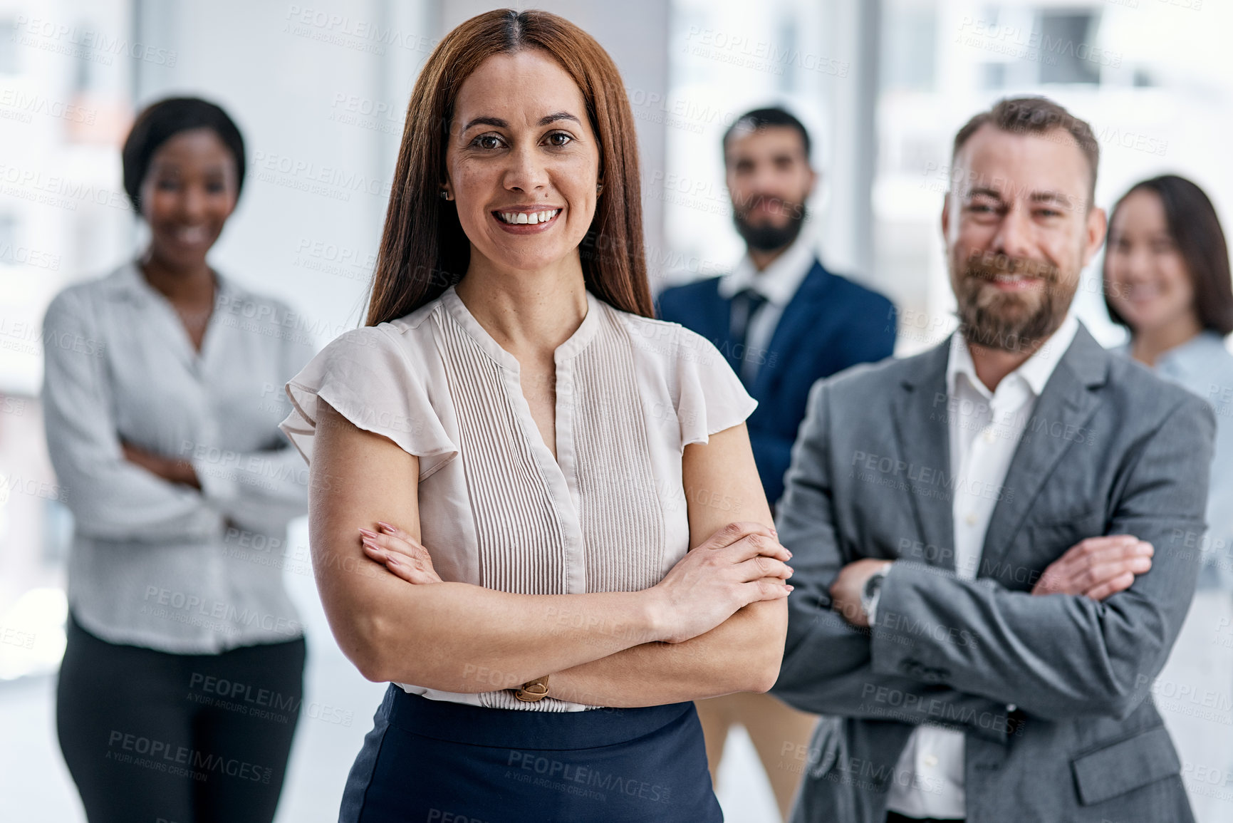 Buy stock photo Portrait of a businesswoman standing in an office with her colleagues in the background