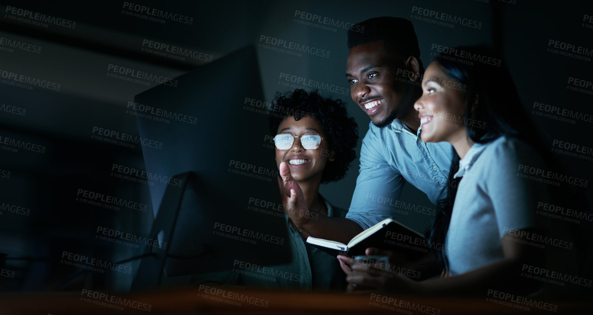 Buy stock photo Shot of a group of young businesspeople using a computer together during a late night at work