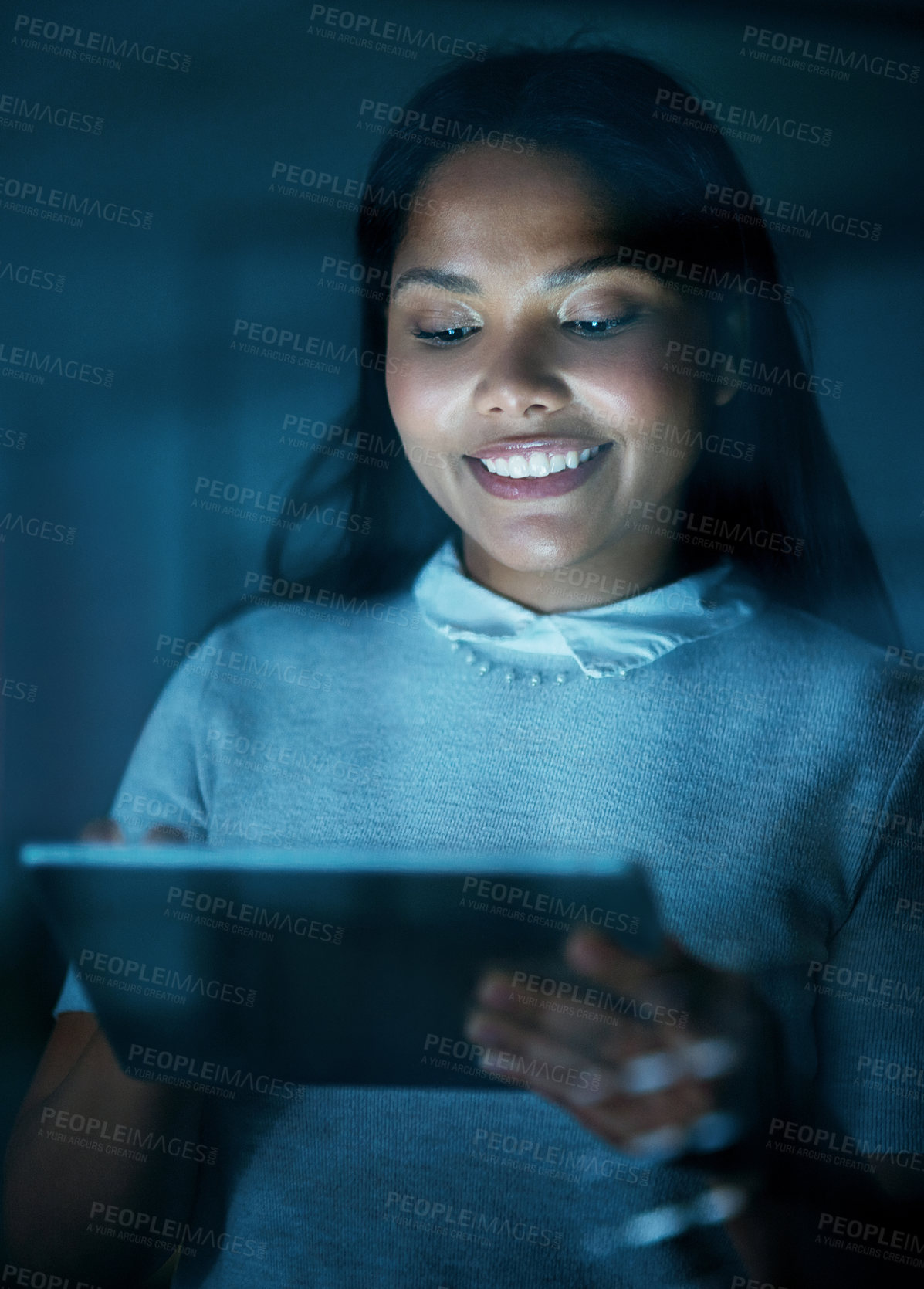 Buy stock photo Shot of a young businesswoman using a digital tablet during a late night at work