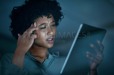 Buy stock photo Shot of a young businesswoman looking confused while using a digital tablet during a late night at work