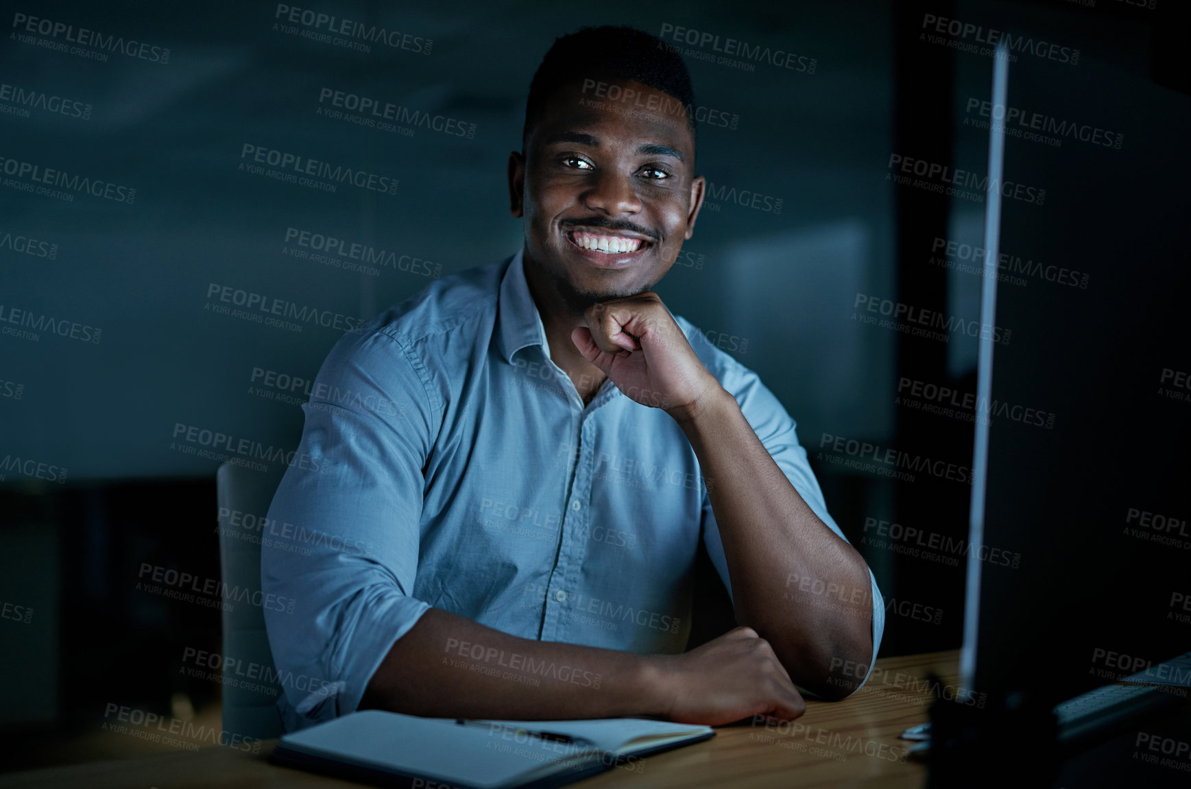 Buy stock photo Portrait of a young businessman using a computer during a late night at work