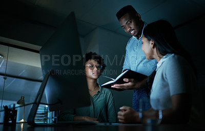 Buy stock photo Shot of a group of young businesspeople using a computer together during a late night at work