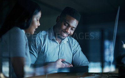 Buy stock photo Shot of a young businesswoman and businessman using a computer together during a late night at work