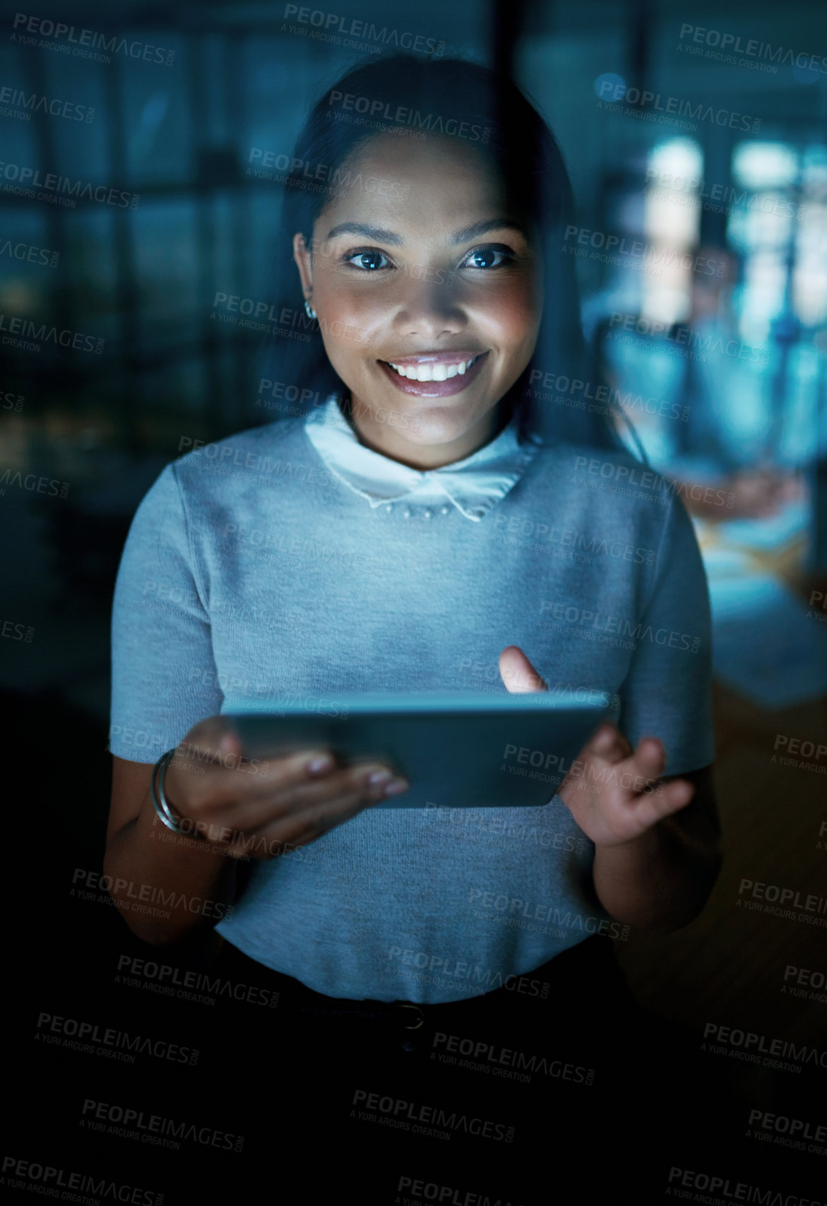 Buy stock photo Shot of a young businesswoman using a digital tablet during a late night at work