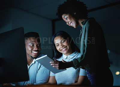 Buy stock photo Shot of a group of young businesspeople using a digital tablet and computer during a late night at work