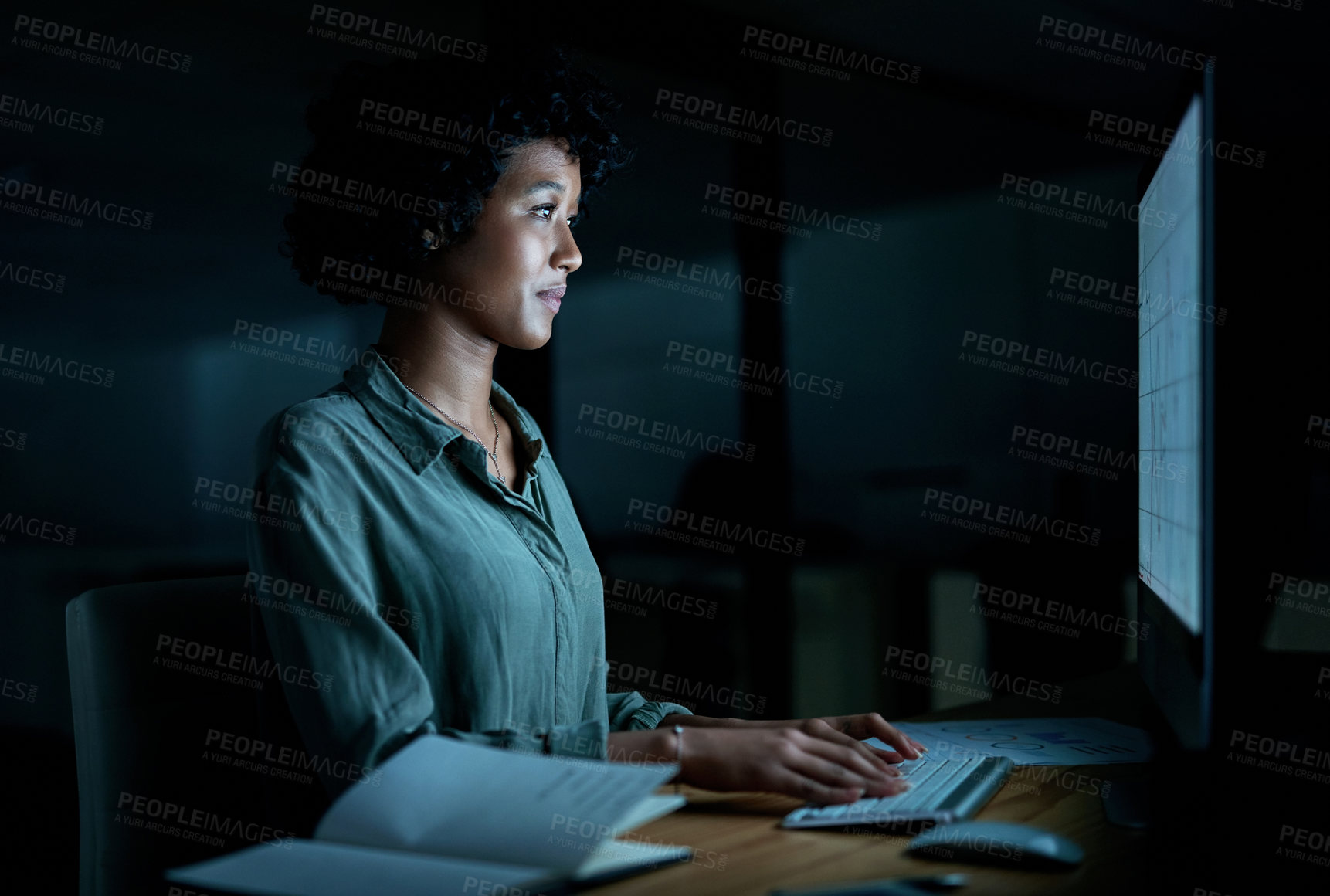 Buy stock photo Shot of a young businesswoman using a computer during a late night at work