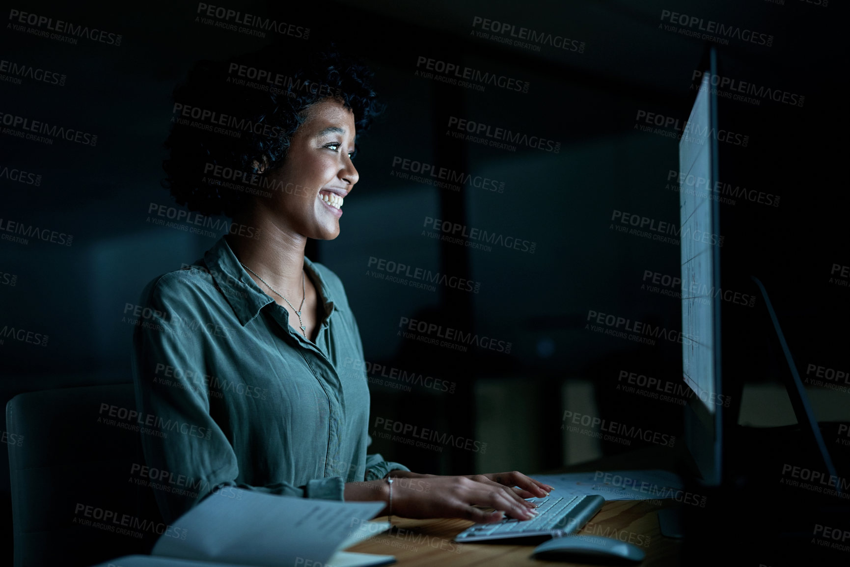 Buy stock photo Shot of a young businesswoman using a computer during a late night at work