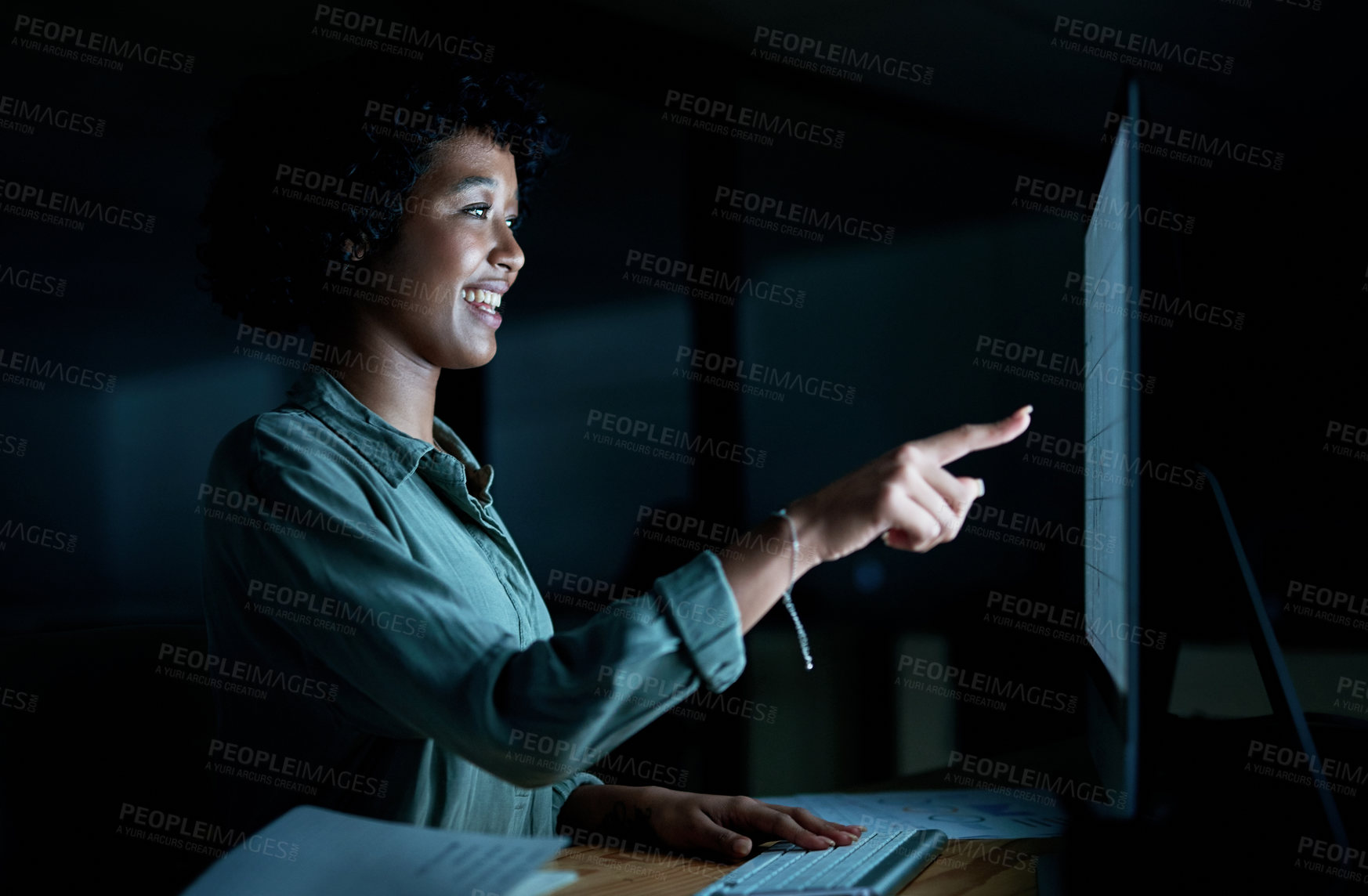 Buy stock photo Shot of a young businesswoman using a computer to make a video call during a late night at work