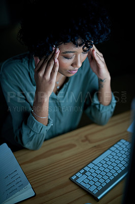 Buy stock photo Shot of a young businesswoman looking stressed while using a computer during a late night at work