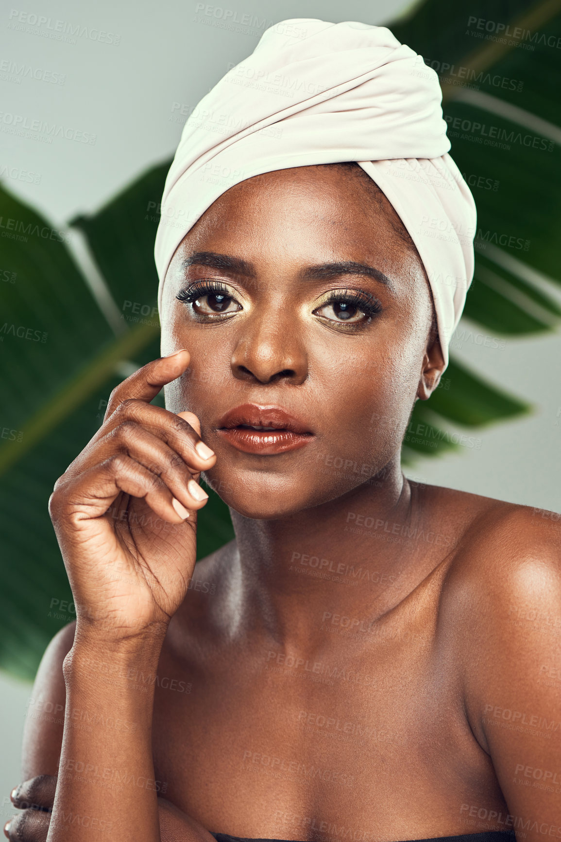 Buy stock photo Studio shot of a beautiful young woman posing against a leafy background