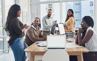 Buy stock photo Cropped shot of a diverse group of businesspeople using technology during a meeting in the office during the day