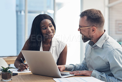 Buy stock photo Cropped shot of two young businesspeople sitting together and having a discussion in the office