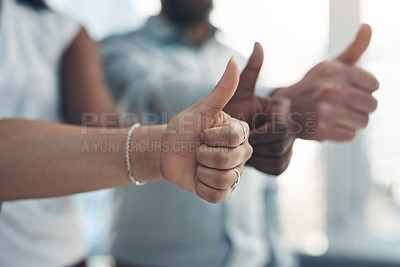 Buy stock photo Cropped shot of an unrecognizable group of businesspeople standing together and making a thumbs-up gesture in the office