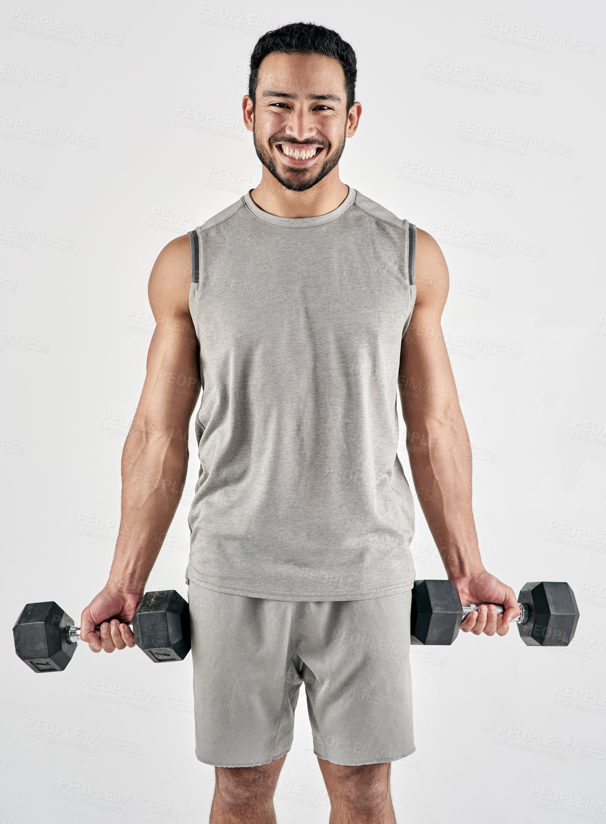 Buy stock photo Studio portrait of a muscular young man exercising with dumbbells against a white background