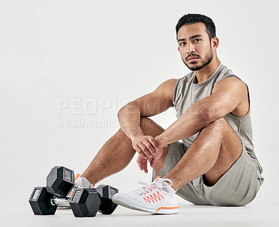 Buy stock photo Studio portrait of a muscular young man posing with dumbbells against a white background