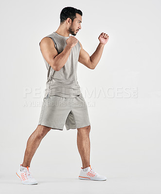 Buy stock photo Studio shot of a muscular young man posing in fighting stance against a white background