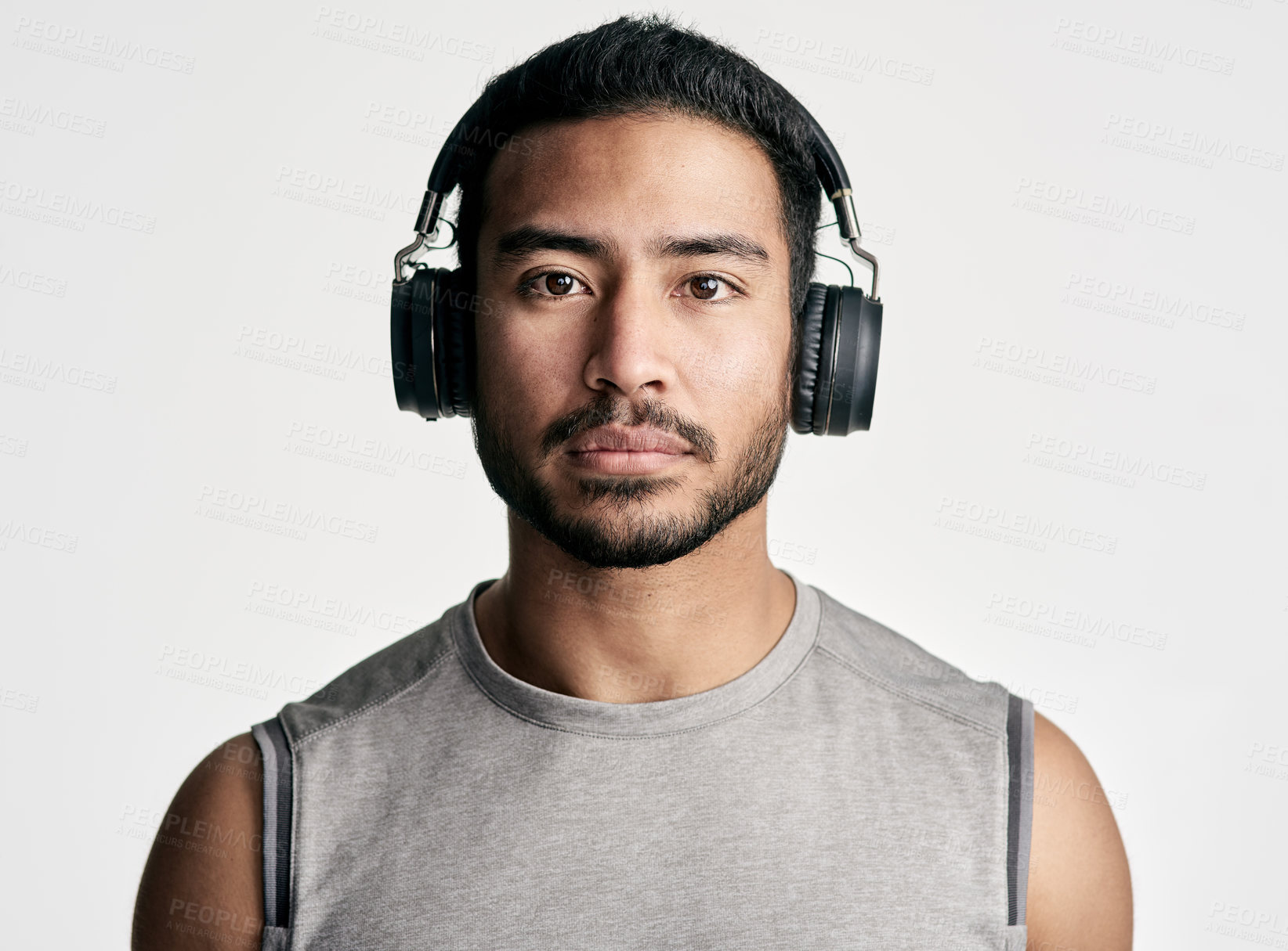 Buy stock photo Studio portrait of a sporty young man wearing headphones against a white background