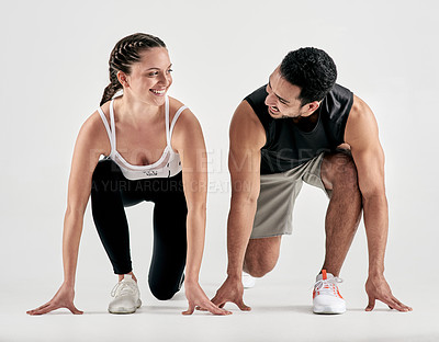 Buy stock photo Studio shot of a sporty young man and woman in starting position against a white background