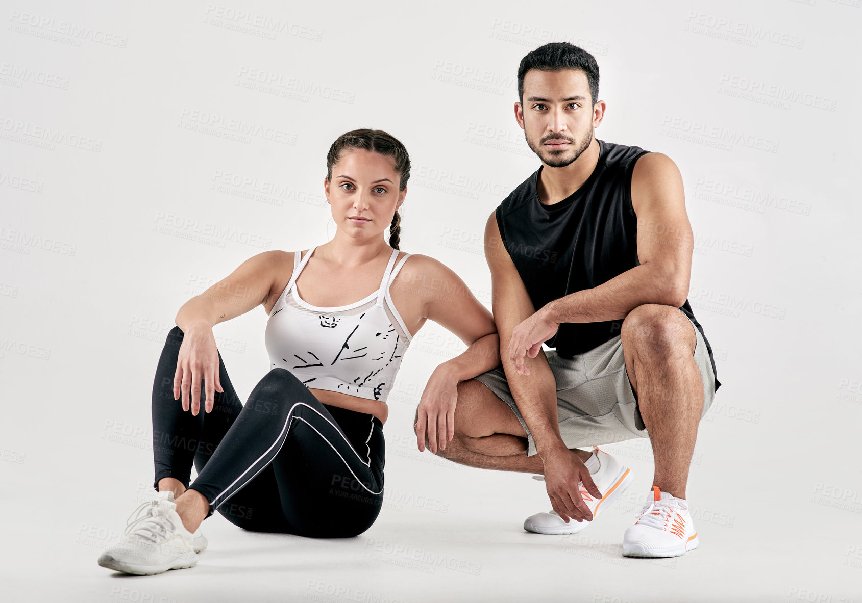 Buy stock photo Studio portrait of a sporty young man and woman posing together against a white background