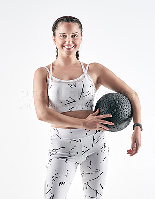 Buy stock photo Studio portrait of a sporty young woman holding an exercise ball against a white background