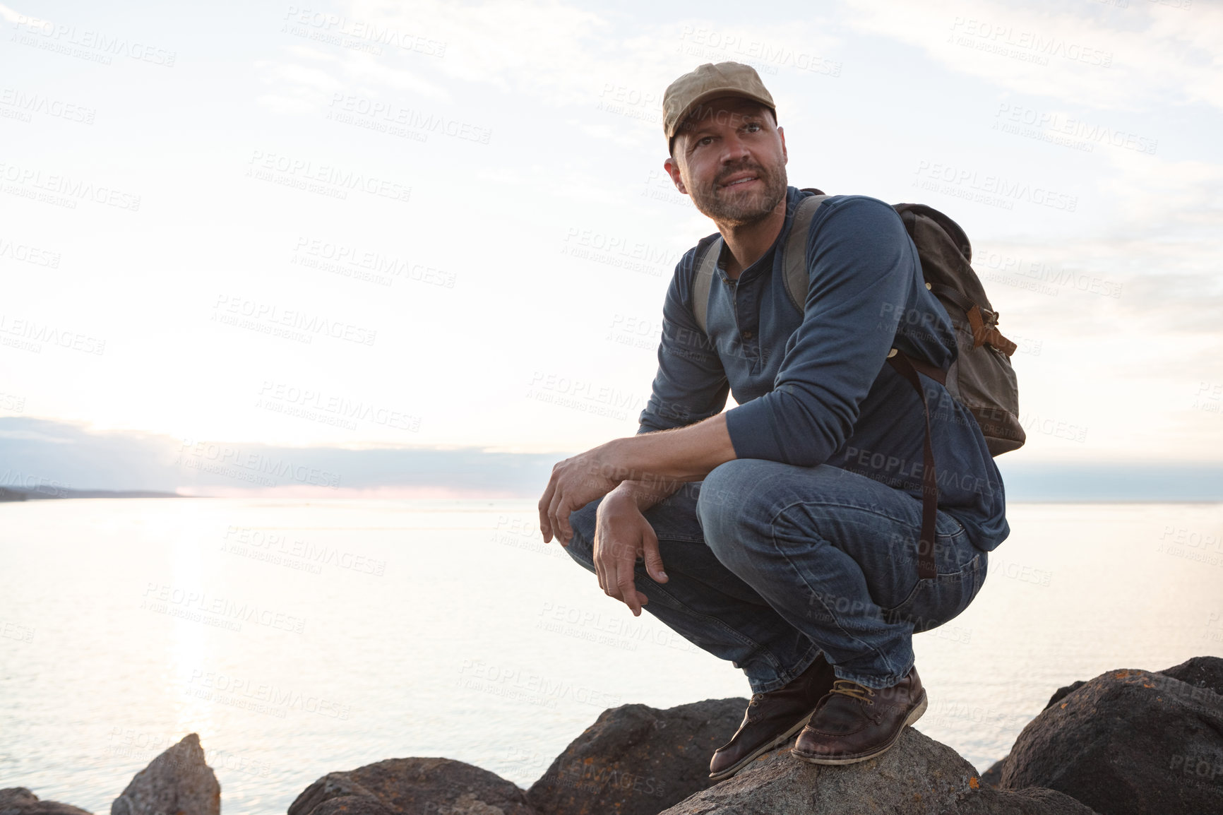 Buy stock photo Shot of a man wearing his backpack while out for a hike on a coastal trail