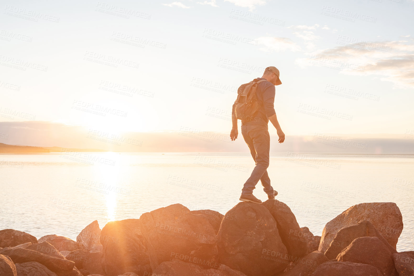 Buy stock photo Shot of a man wearing his backpack while out for a hike on a coastal trail