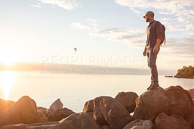 Buy stock photo Shot of a man looking at the ocean while out hiking