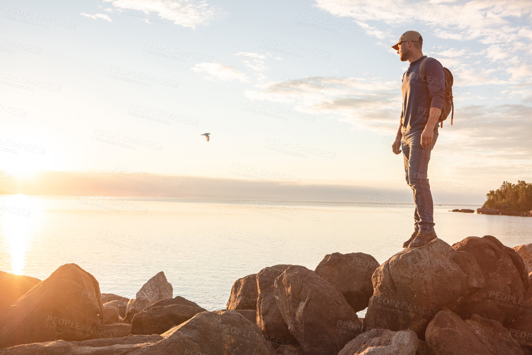 Buy stock photo Shot of a man looking at the ocean while out hiking